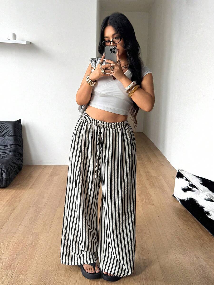 Women's loose straight leg cotton pants featuring a high waist with an adjustable drawstring knot and functional side pockets.