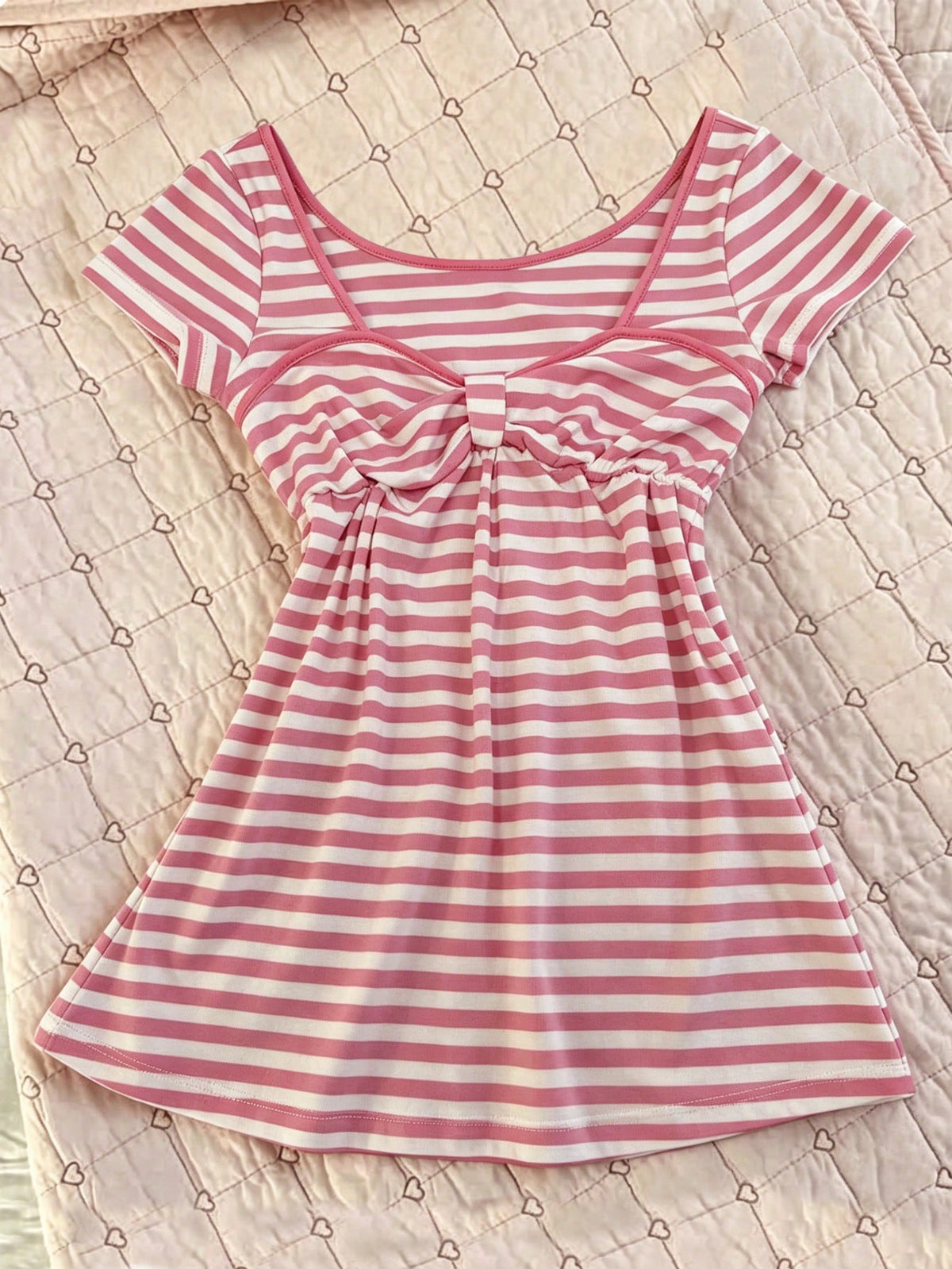 Women's hot pink short sleeve vacation top featuring a heart shape neckline, twist detail, and raglan sleeves.