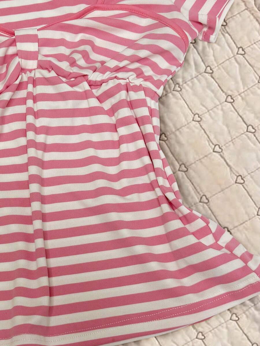 Women's hot pink short sleeve vacation top featuring a heart shape neckline, twist detail, and raglan sleeves.