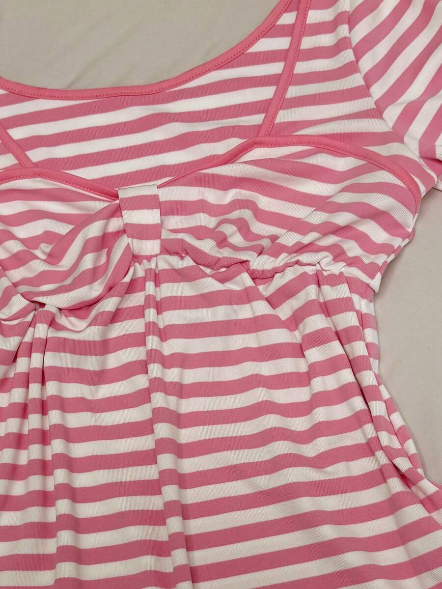 Women's hot pink short sleeve vacation top featuring a heart shape neckline, twist detail, and raglan sleeves.