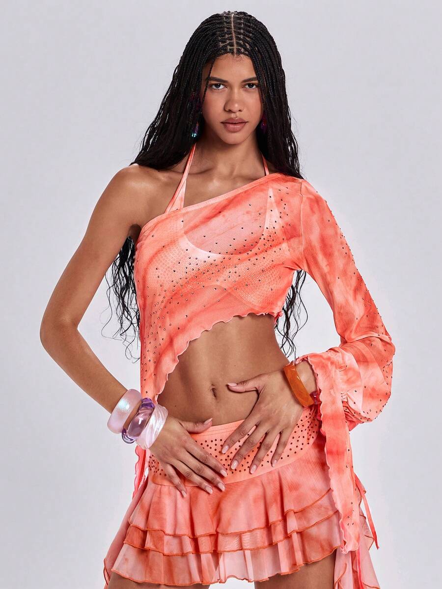Women's one shoulder crop top featuring an asymmetrical long sleeve, colorful print, and sparkling rhinestone embellishments.