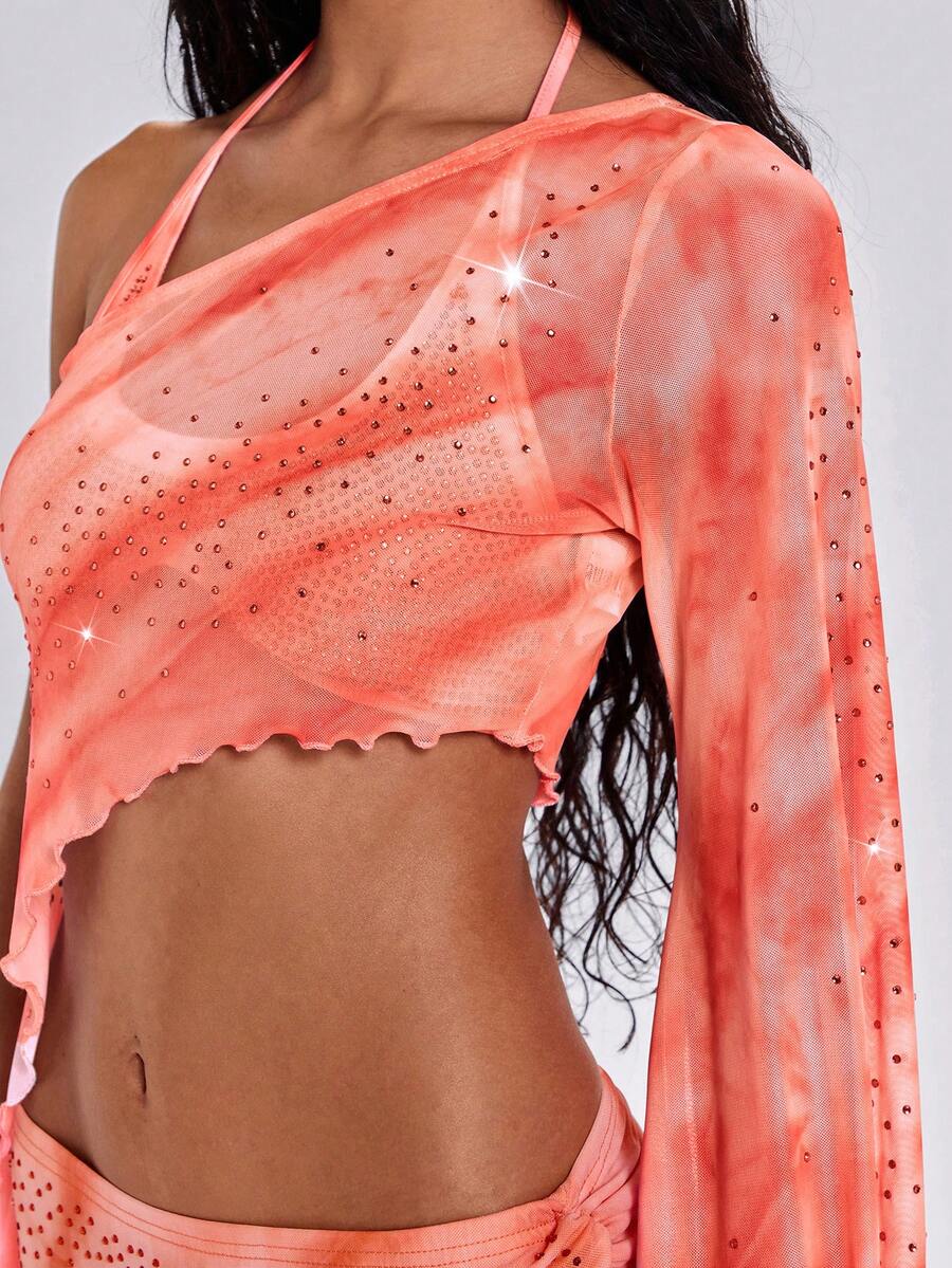 Women's one shoulder crop top featuring an asymmetrical long sleeve, colorful print, and sparkling rhinestone embellishments.