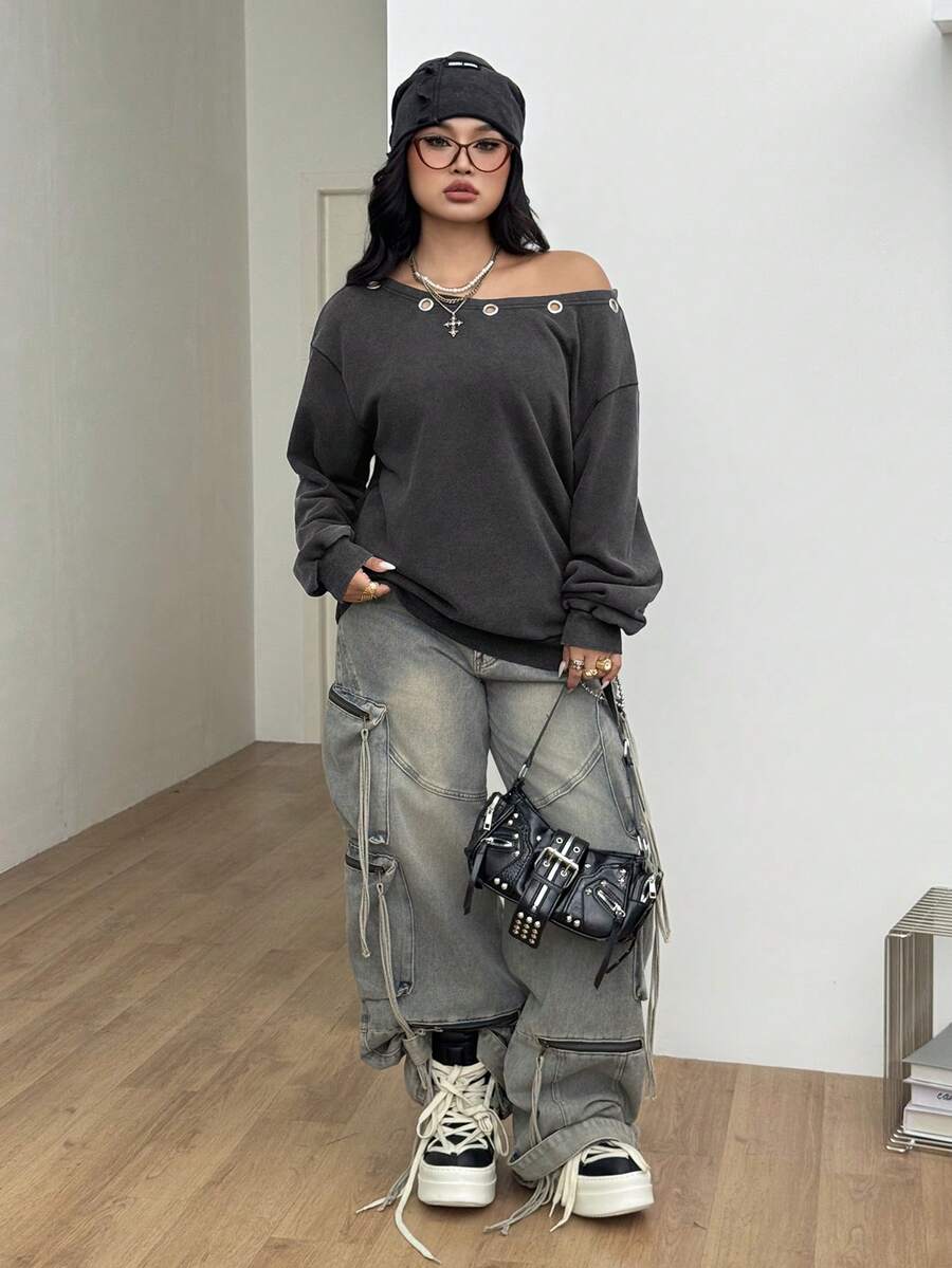 Women's oversized dark grey long sleeve sweatshirt featuring an asymmetrical boat neckline with grommet eyelet details and drop shoulders.