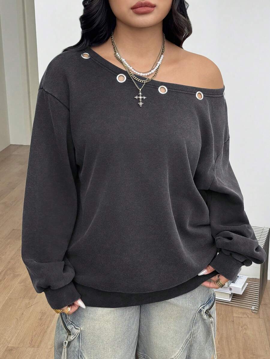 Women's oversized dark grey long sleeve sweatshirt featuring an asymmetrical boat neckline with grommet eyelet details and drop shoulders.