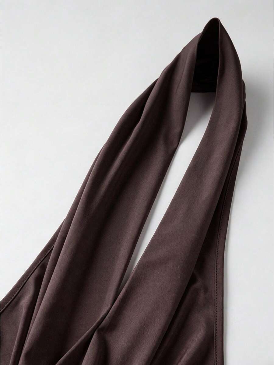Women's backless halter crop top featuring a draped cowl front, knot detail, and slim fit design.