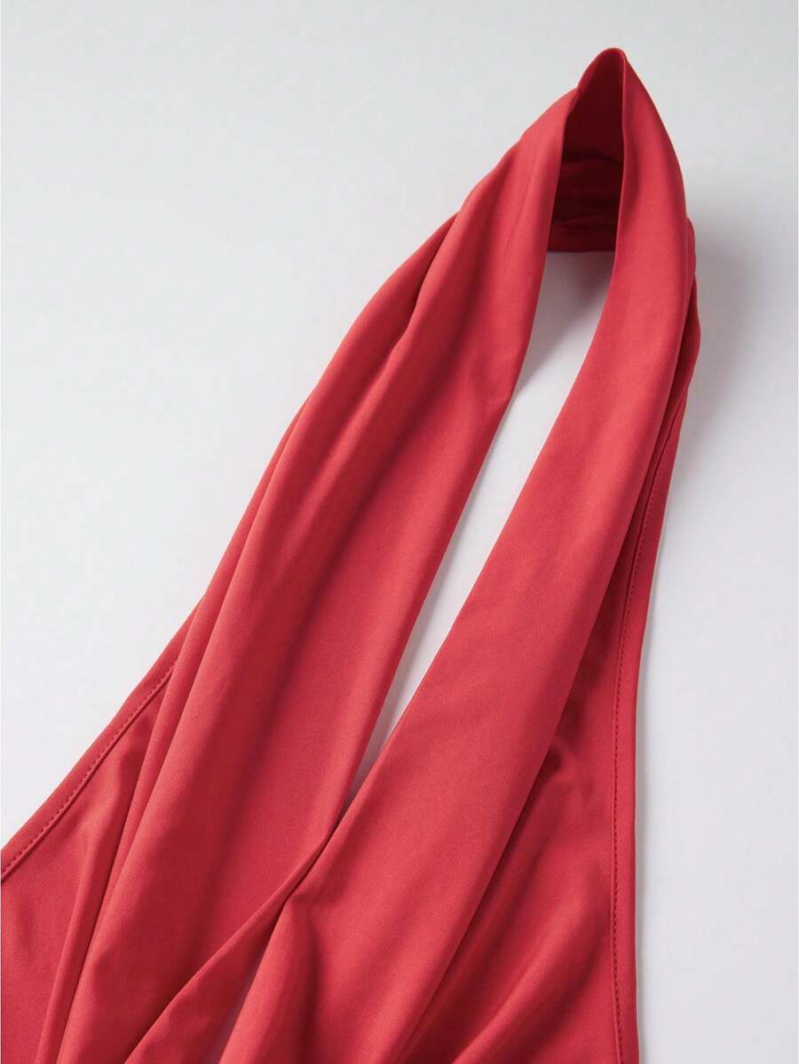 Women's backless halter crop top featuring a draped cowl front, knot detail, and slim fit design.