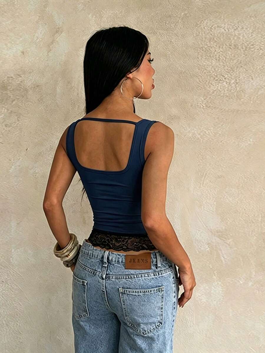 Women's white sleeveless crop tank top with contrast lace details, strap neckline, and graphic plant pattern in a slim fit.