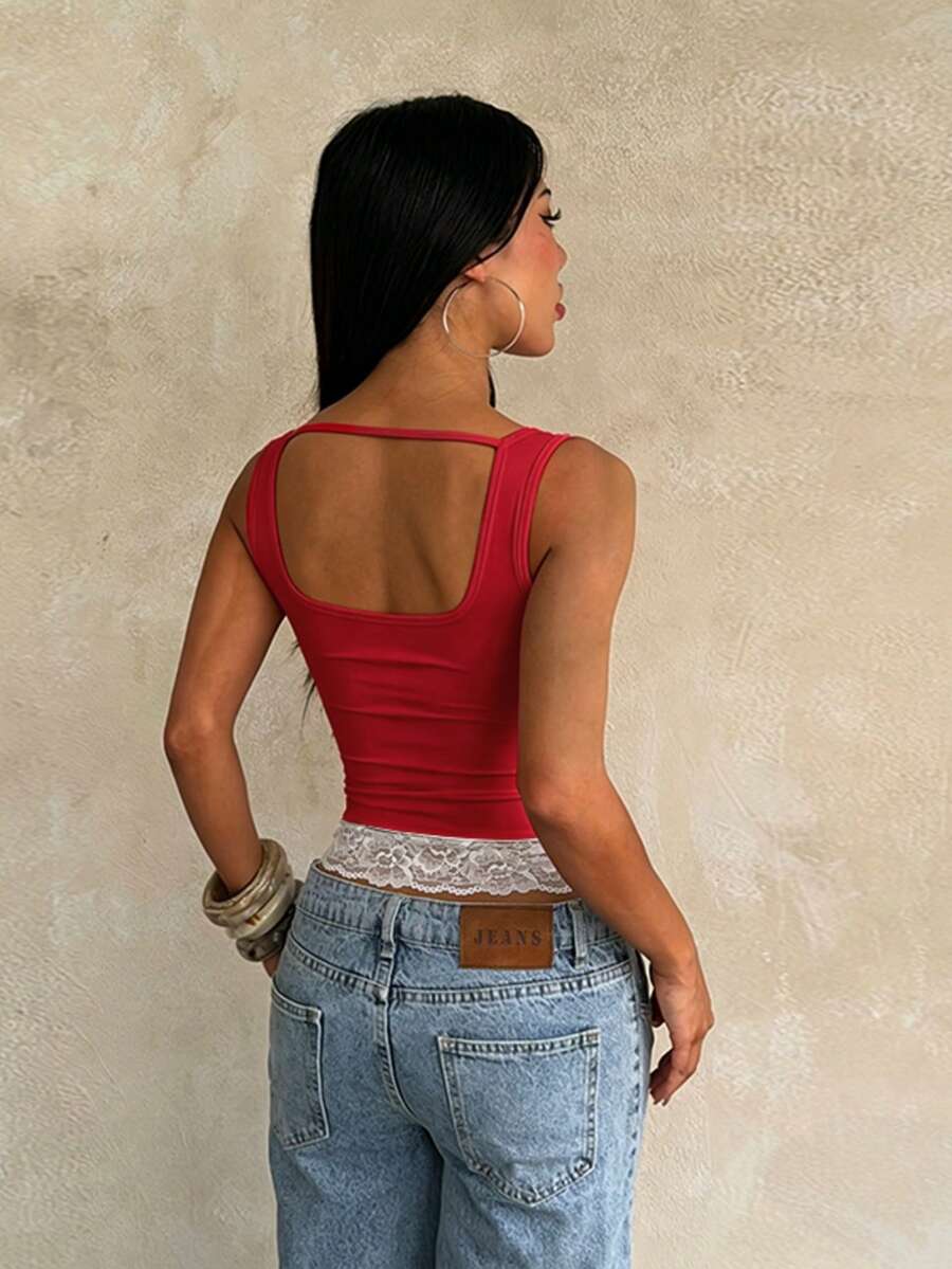 Women's white sleeveless crop tank top with contrast lace details, strap neckline, and graphic plant pattern in a slim fit.