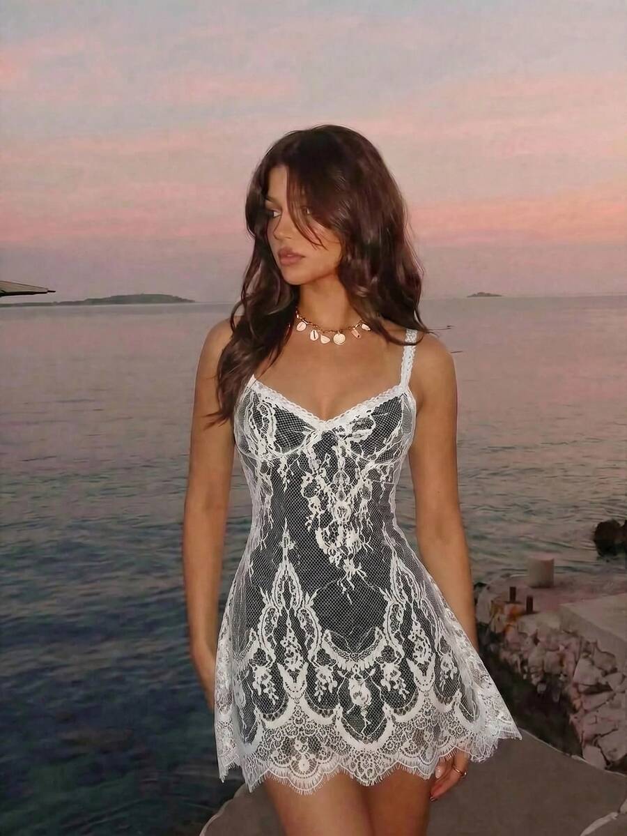 Women's short lace cami dress with spaghetti straps, contrast lace detailing, high waist, slim fit, and straight hem.