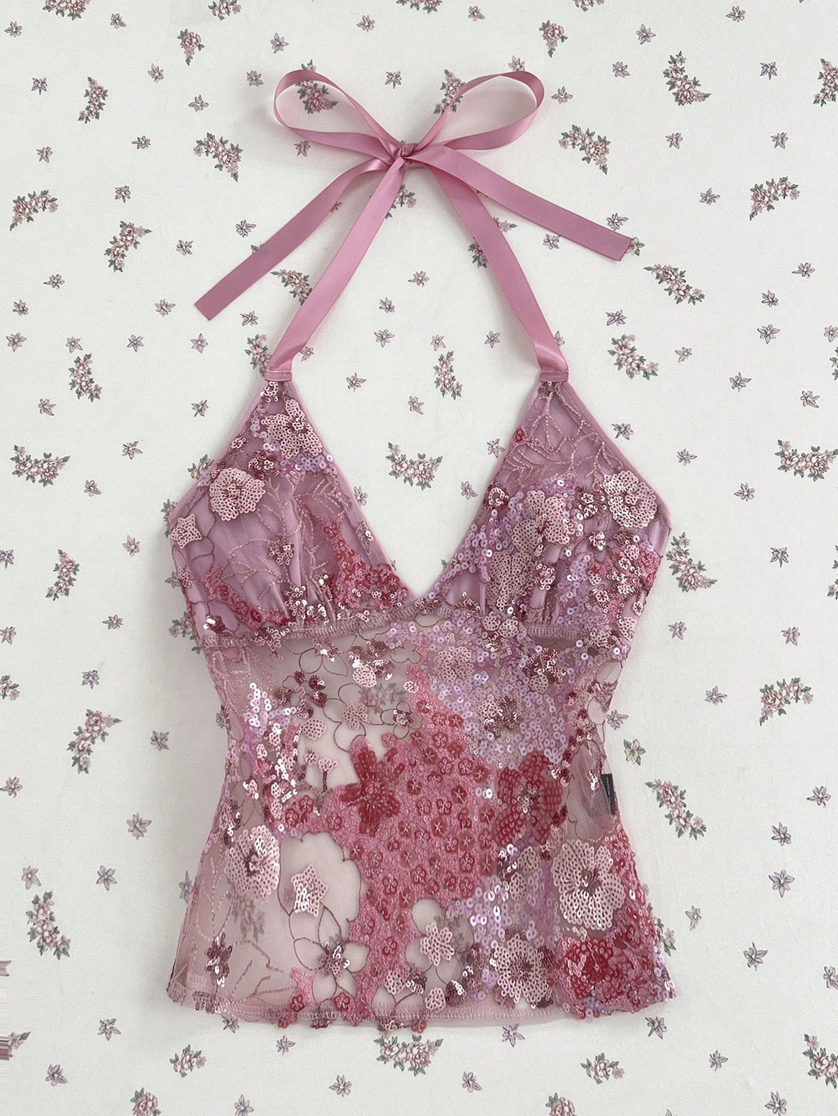 Pink sheer lace tie-up halter crop top featuring floral sequin patchwork, deep V-neck, and backless tie-back design.