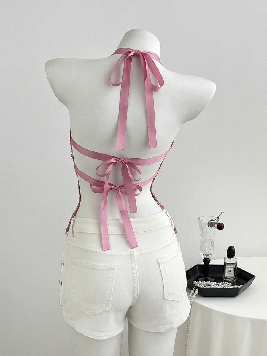 Pink sheer lace tie-up halter crop top featuring floral sequin patchwork, deep V-neck, and backless tie-back design.