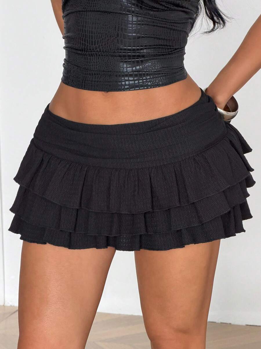 Women's white low waist tiered mini skirt featuring ruched detailing and a slight-stretch knitted fabric.