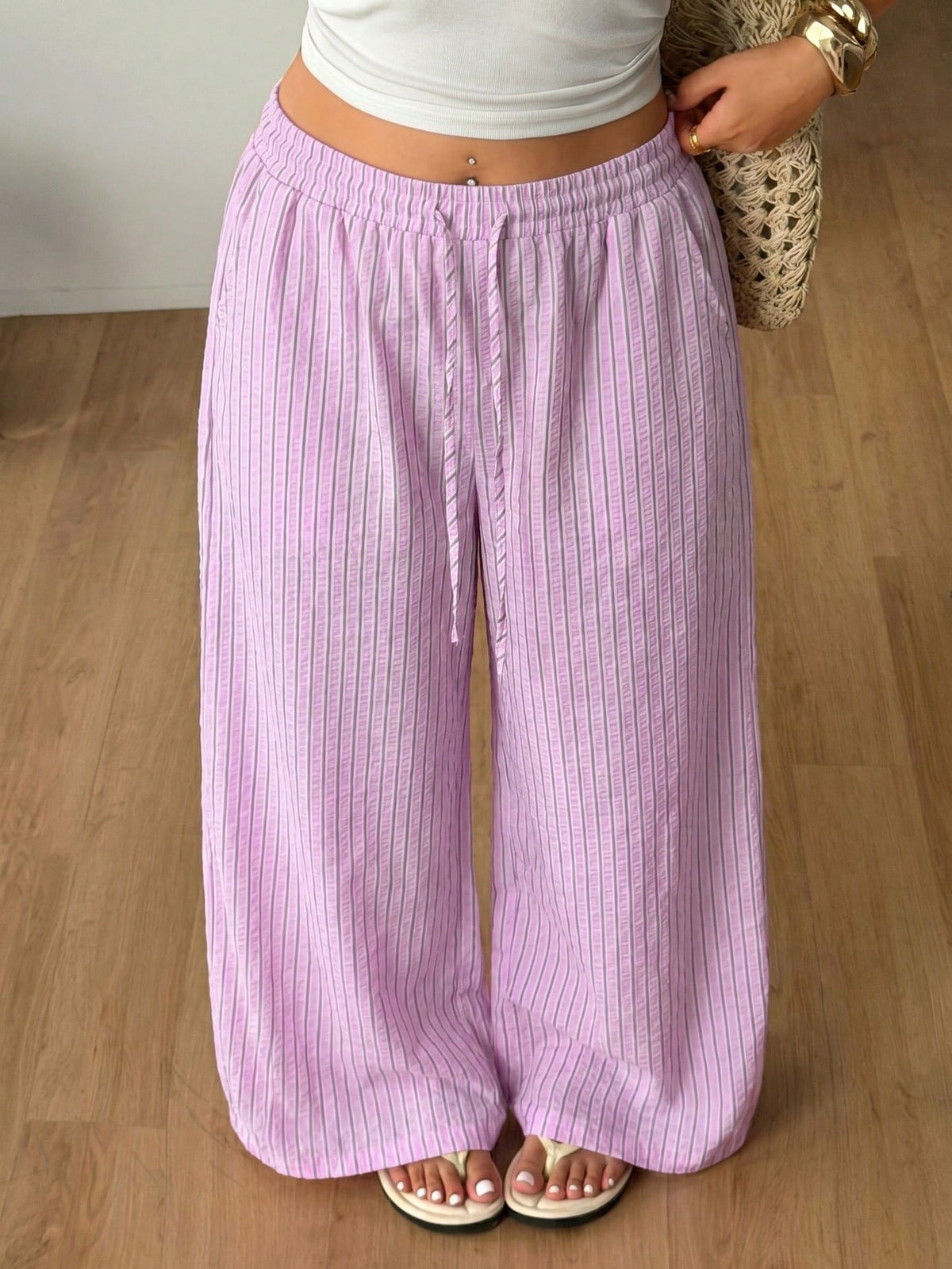 Plus size women's striped loose straight leg cropped pants with pleated detailing and side pockets