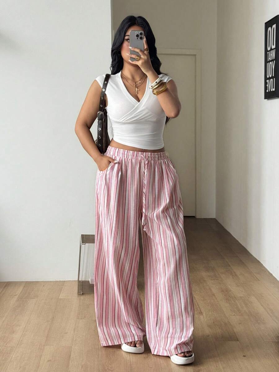 Women's loose straight leg cotton pants featuring a high waist with an adjustable drawstring knot and functional side pockets.