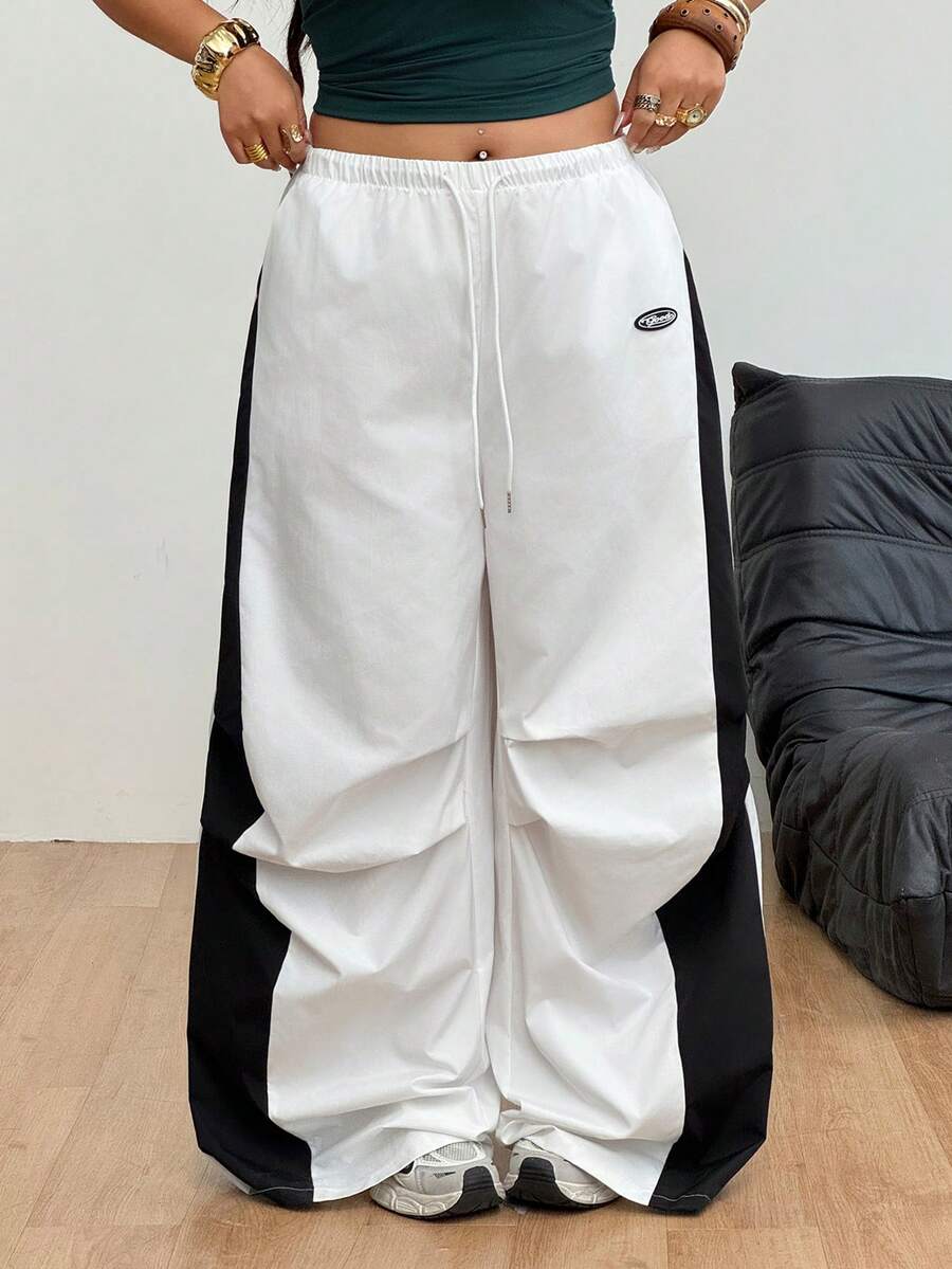 Women's high waist wide leg pants in black featuring leopard print patchwork details and an elastic drawstring waistband.