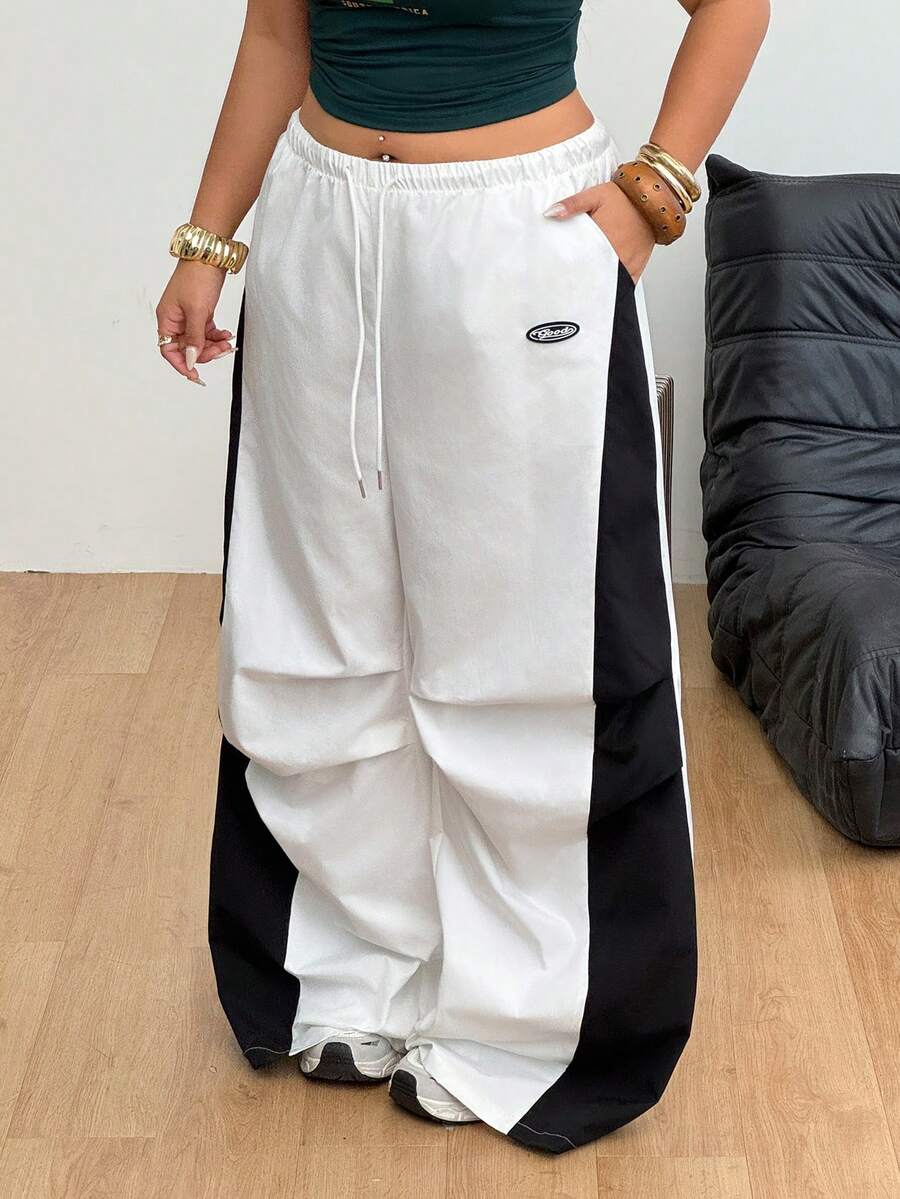 Women's high waist wide leg pants in black featuring leopard print patchwork details and an elastic drawstring waistband.