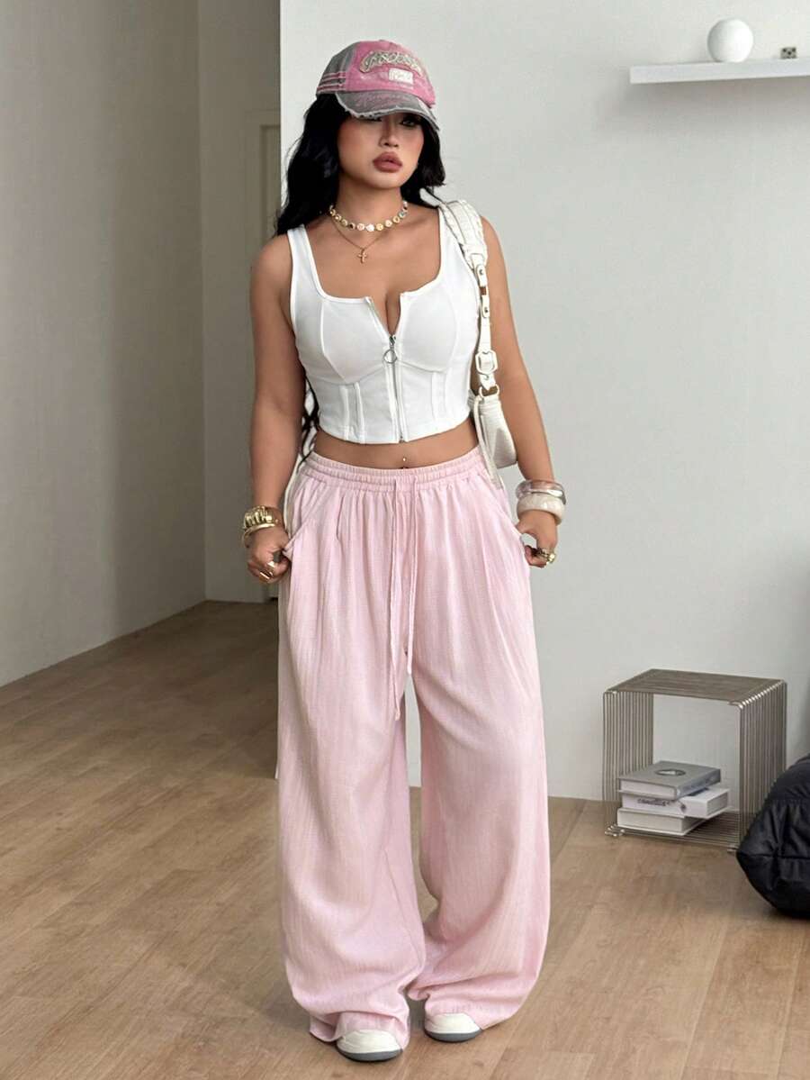 Women's loose straight leg cotton pants featuring a high waist with an adjustable drawstring knot and functional side pockets.