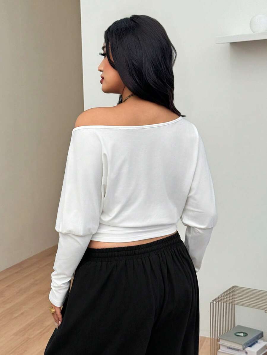 Women's black asymmetrical neck t-shirt featuring batwing sleeves and a slim fit knitted design.