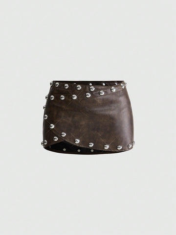 Women's bodycon mini skirt featuring an ultra low layered waistline with studded rivet details in a solid color finish.