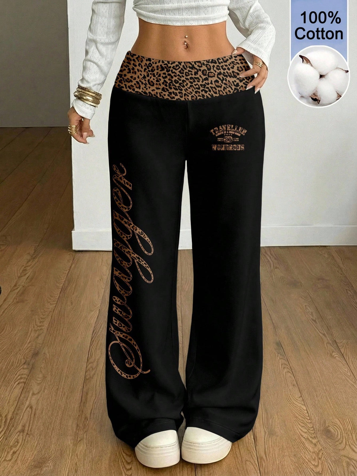Women's black leopard print flare leg sweatpants with an elastic mid waist crafted from cotton knitted fabric.