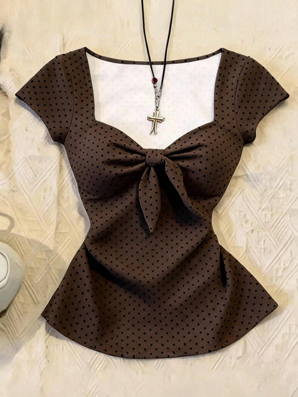 Women's polka dot short sleeve raglan t-shirt with a twist front detail and contrast collar.