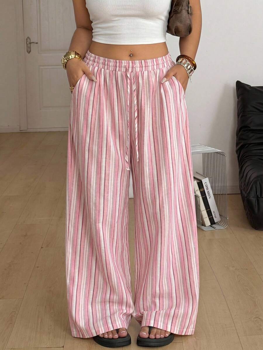 Women's loose straight leg cotton pants featuring a high waist with an adjustable drawstring knot and functional side pockets.