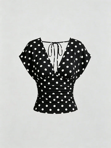 Women's black knitted t-shirt featuring a reversible deep v-neckline, batwing cap sleeves, ruched detailing, and a slim fit waist.