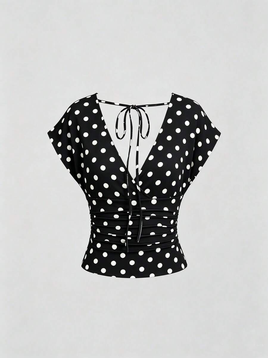 Women's black knitted t-shirt featuring a reversible deep v-neckline, batwing cap sleeves, ruched detailing, and a slim fit waist.