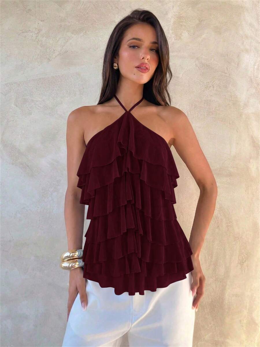 Women's sleeveless halter neck top featuring tiered ruffle layers, a backless cut, and an asymmetrical hem.