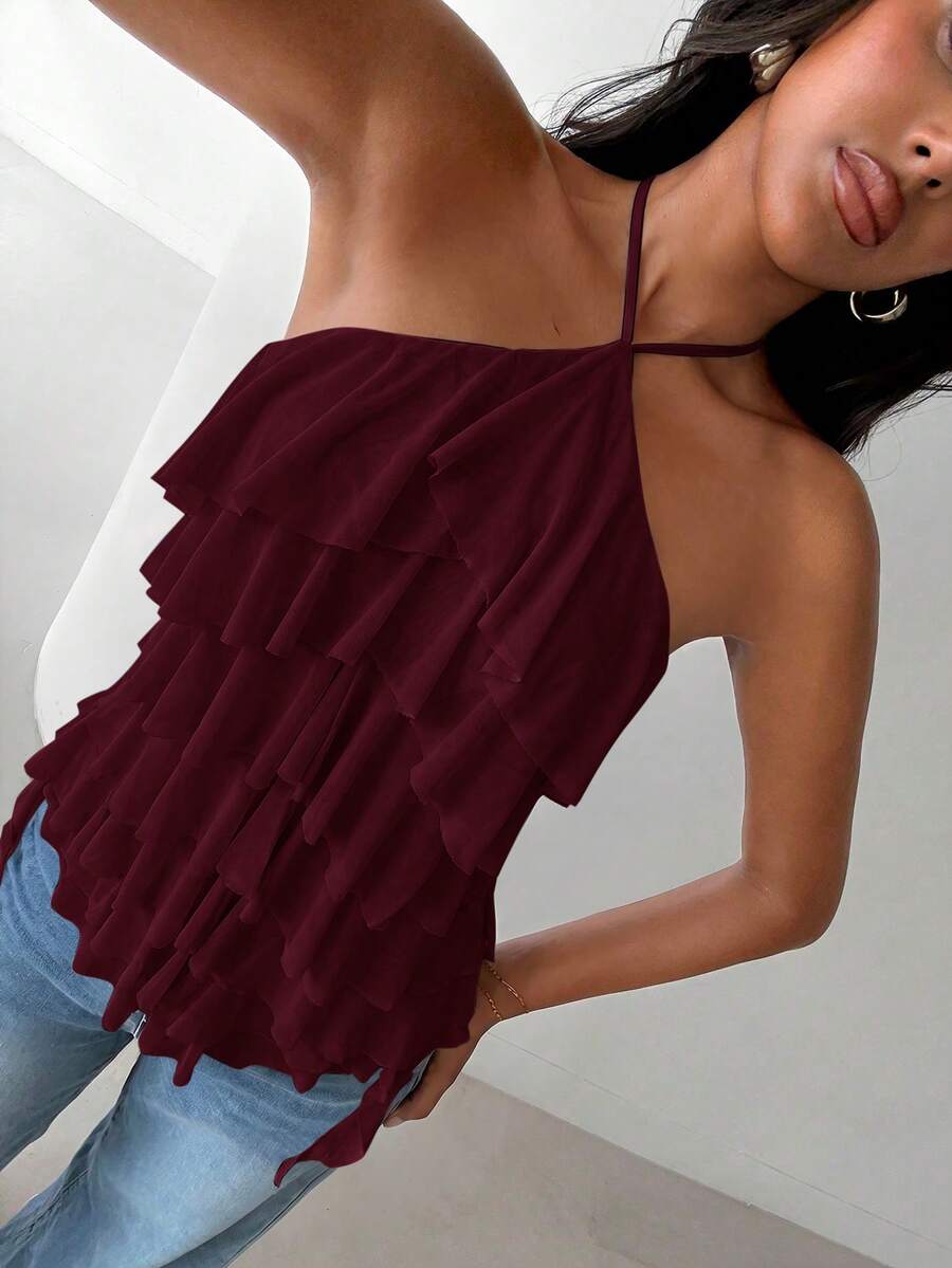 Women's sleeveless halter neck top featuring tiered ruffle layers, a backless cut, and an asymmetrical hem.