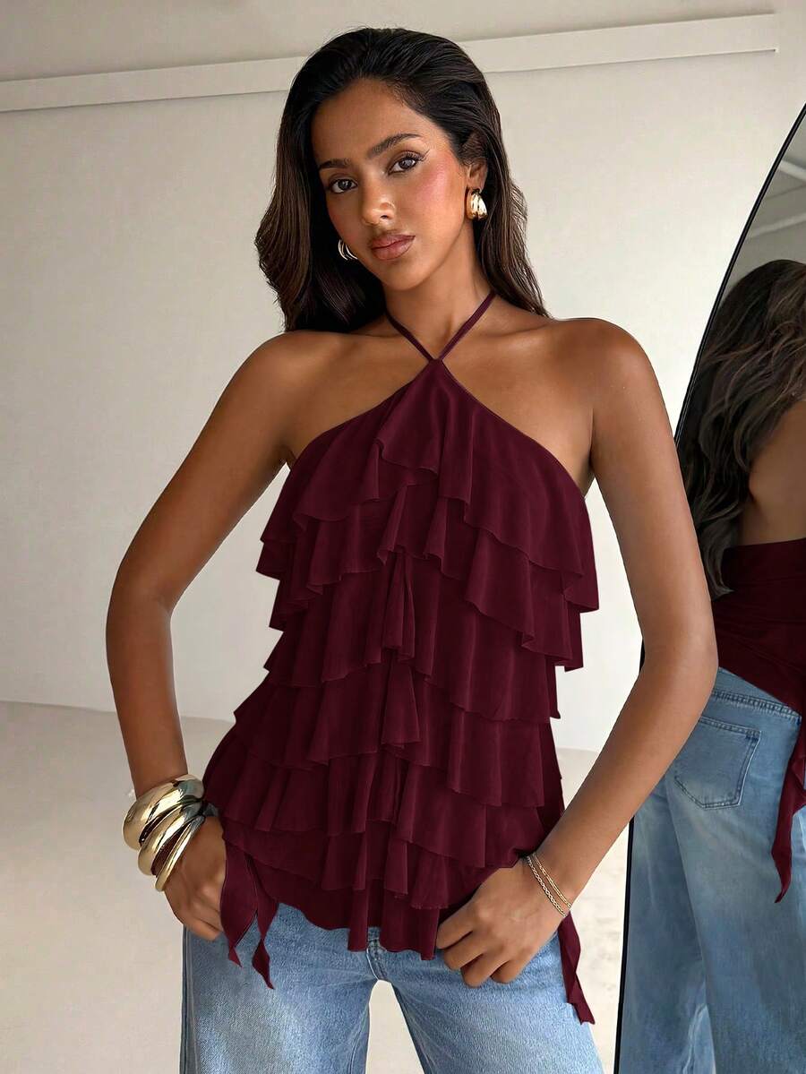 Women's sleeveless halter neck top featuring tiered ruffle layers, a backless cut, and an asymmetrical hem.