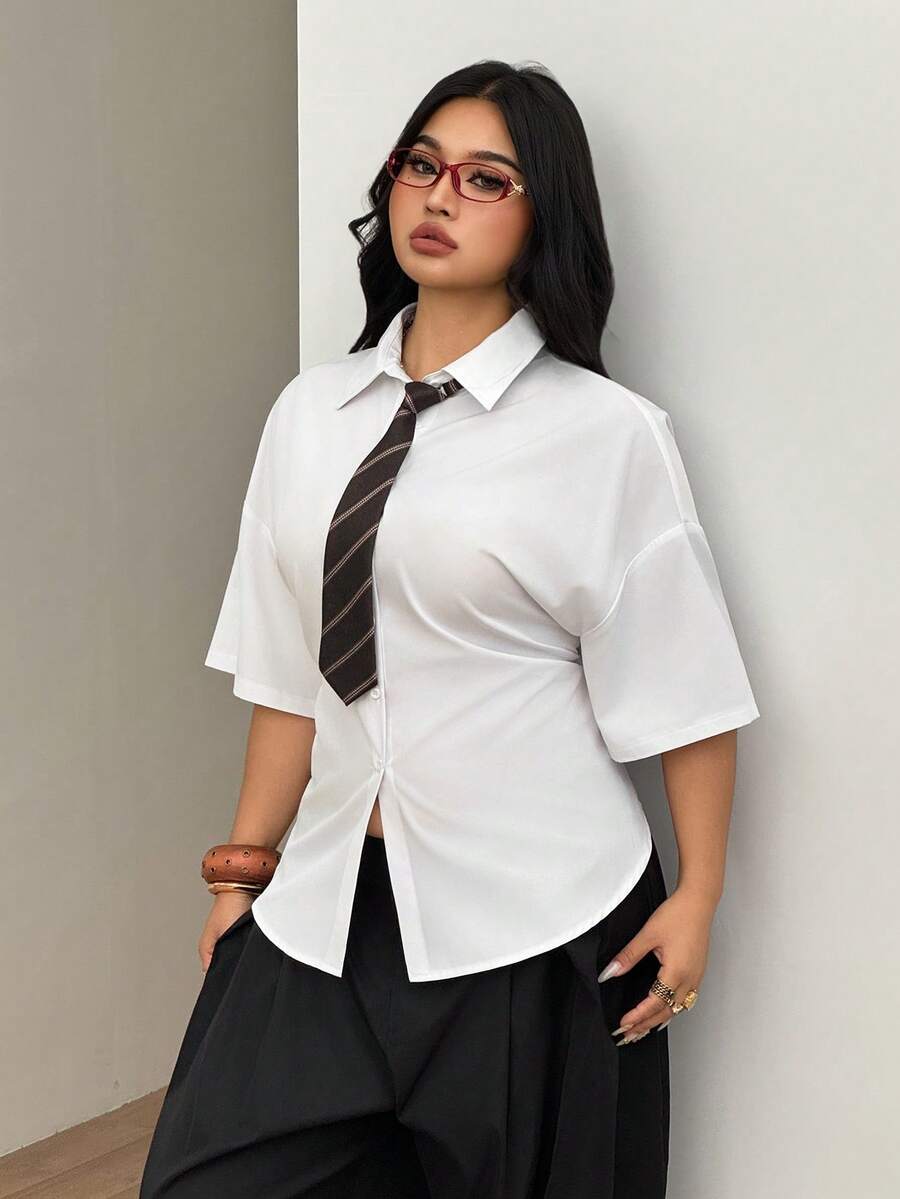 Women's plus size oversized white short sleeve shirt with classic collar, contrast piping, and asymmetrical hem