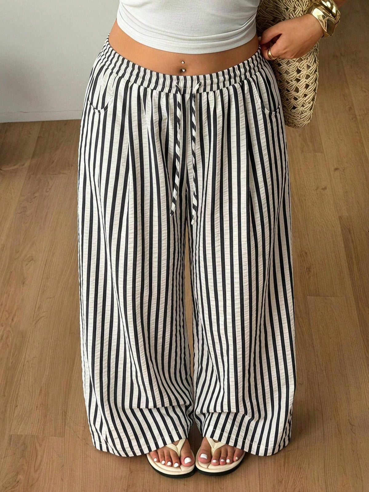 Women's loose straight leg cotton pants featuring a high waist with an adjustable drawstring knot and functional side pockets.