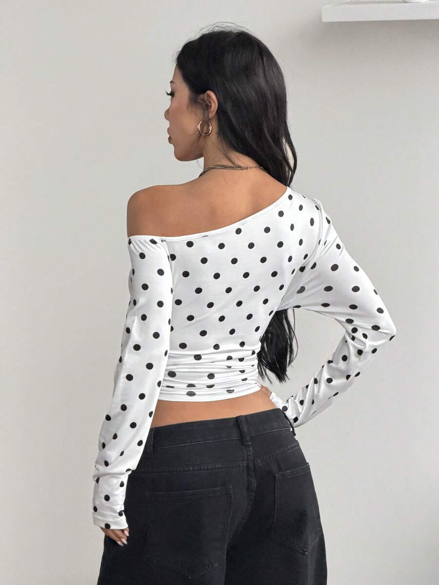Women's slim fit long sleeve knit top featuring an asymmetrical neckline and grommet eyelet detail