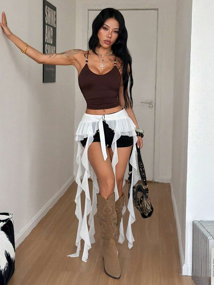 Women's black semi-sheer lace asymmetrical skirt with fringe details, contrast lace, low waist, and ruffle hem for beach, party, concert, or festival outfits.