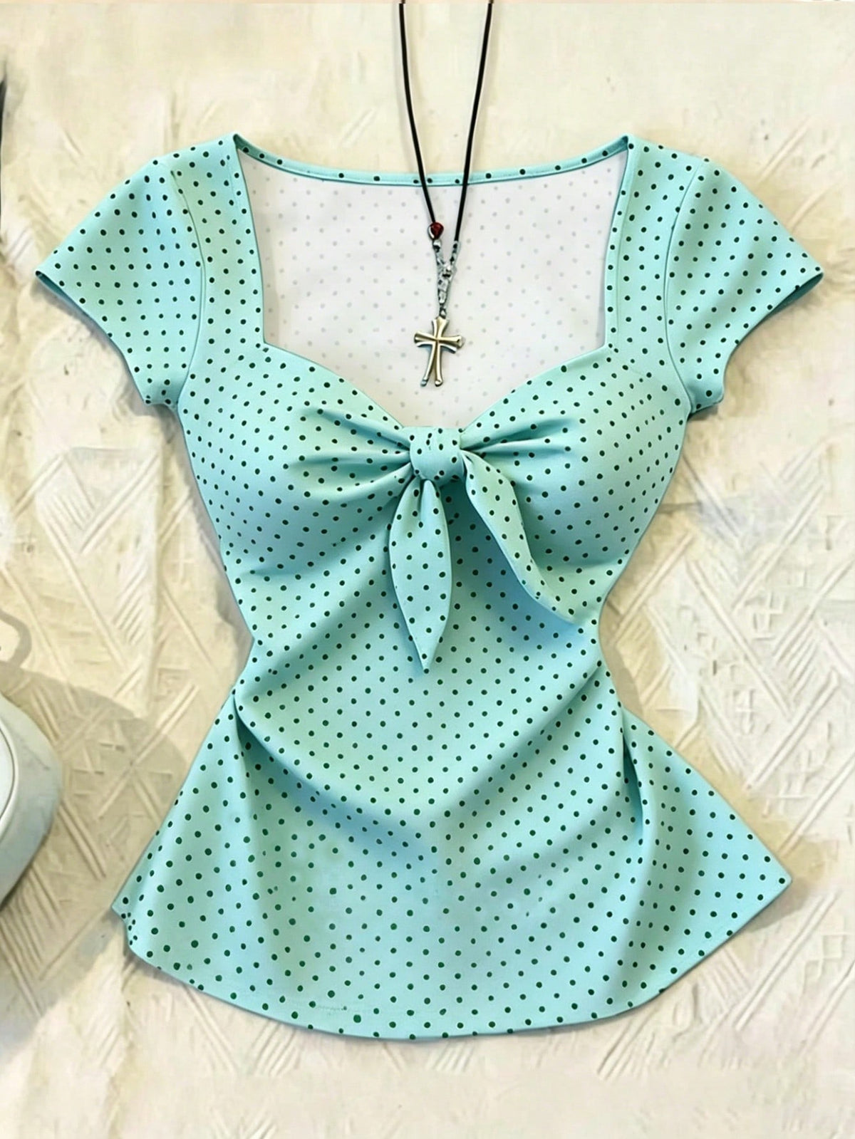 Women's polka dot short sleeve raglan t-shirt with a twist front detail and contrast collar.