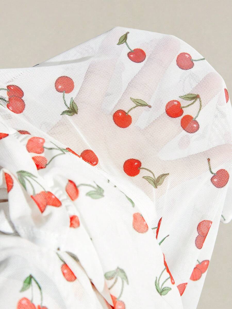 Women's white cherry print cami top with wide straps, ruched knot detail, and an asymmetrical hem