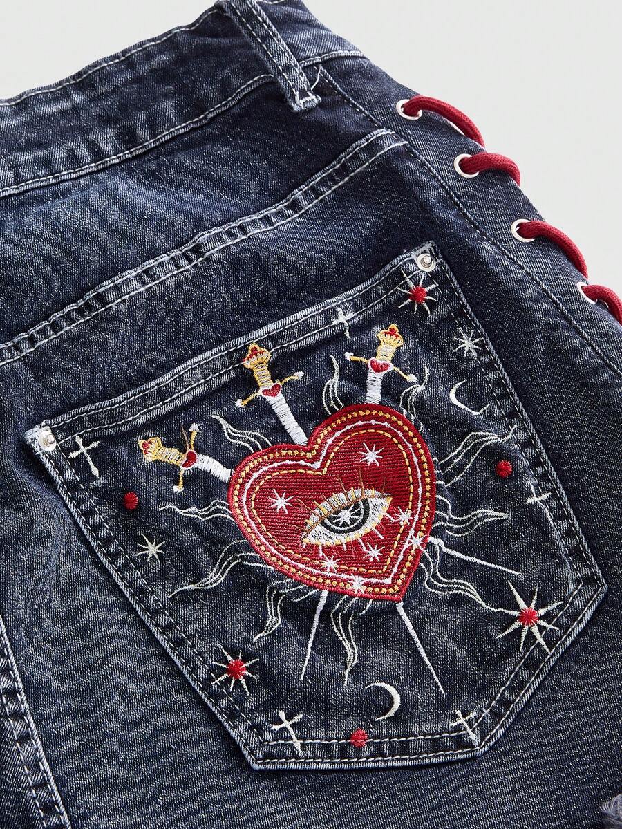 Plus size black gothic mini shorts with heart embroidery, graphic pocket pattern, lace-up detail, raw hem, and zipper fly