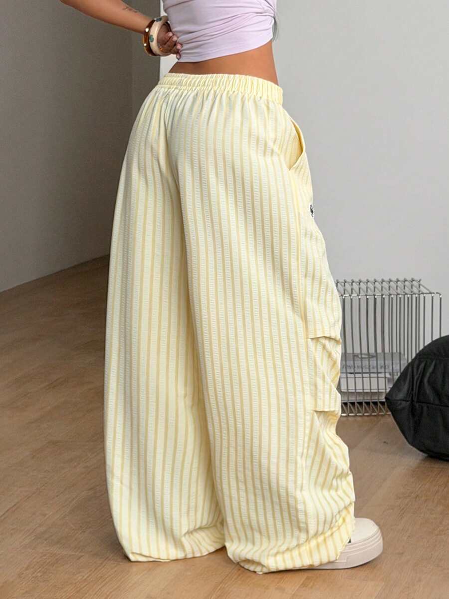Women's black and white striped wide leg pants featuring an elastic drawstring waistband, side pockets, and a loose straight leg fit.