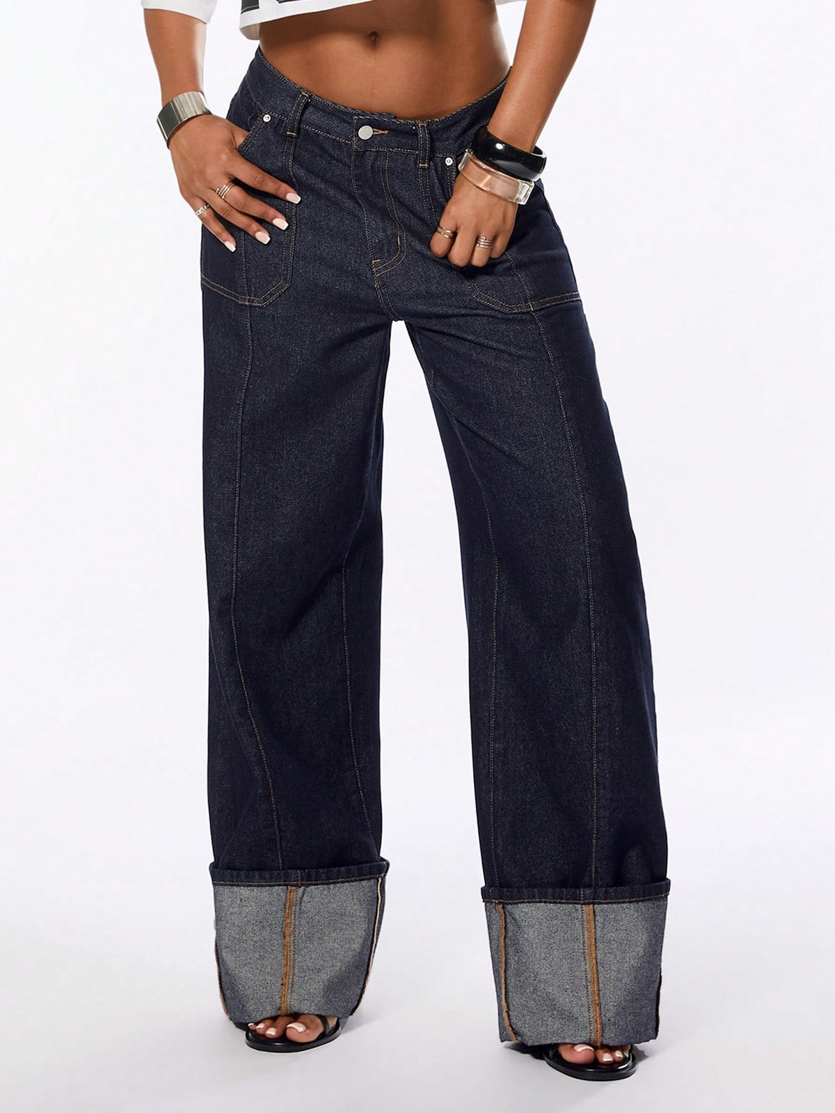Front view of women's blue low waist flared denim jeans featuring a raw wash finish, loose straight leg fit, and zipper fly closure.