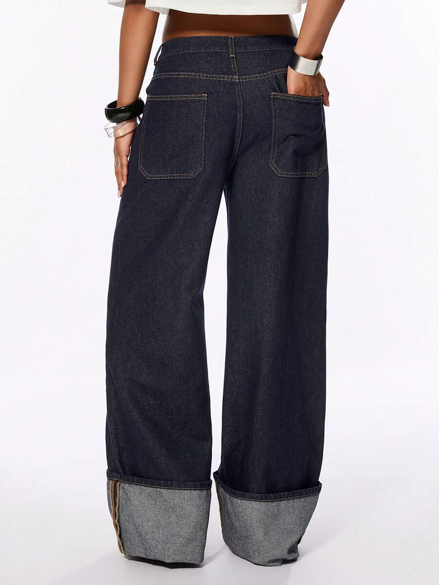 Front view of women's blue low waist flared denim jeans featuring a raw wash finish, loose straight leg fit, and zipper fly closure.