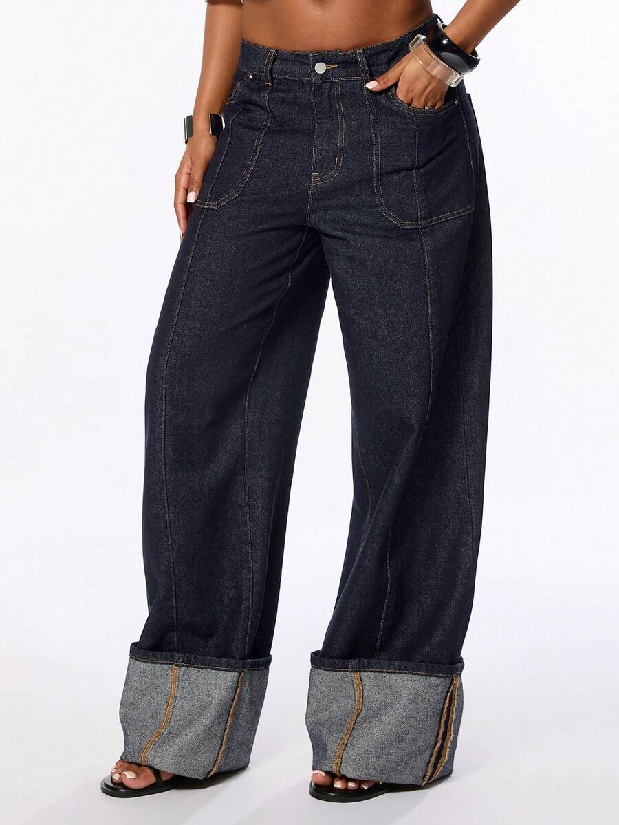 Front view of women's blue low waist flared denim jeans featuring a raw wash finish, loose straight leg fit, and zipper fly closure.