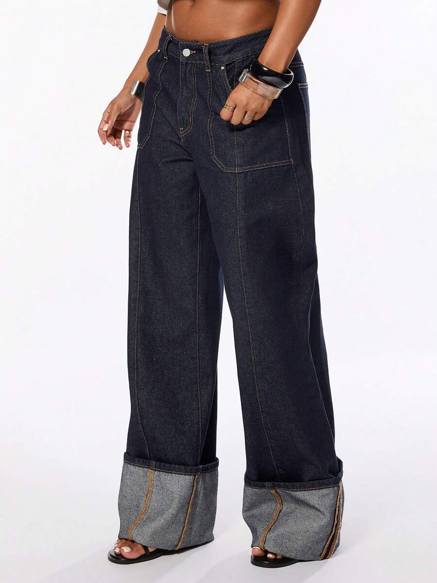 Front view of women's blue low waist flared denim jeans featuring a raw wash finish, loose straight leg fit, and zipper fly closure.