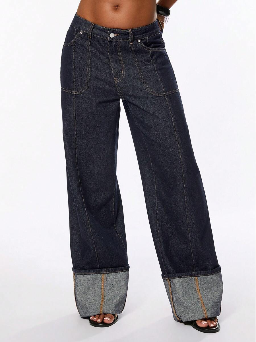 Front view of women's blue low waist flared denim jeans featuring a raw wash finish, loose straight leg fit, and zipper fly closure.