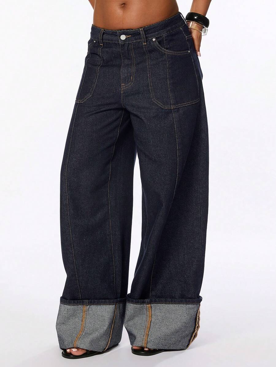 Front view of women's blue low waist flared denim jeans featuring a raw wash finish, loose straight leg fit, and zipper fly closure.