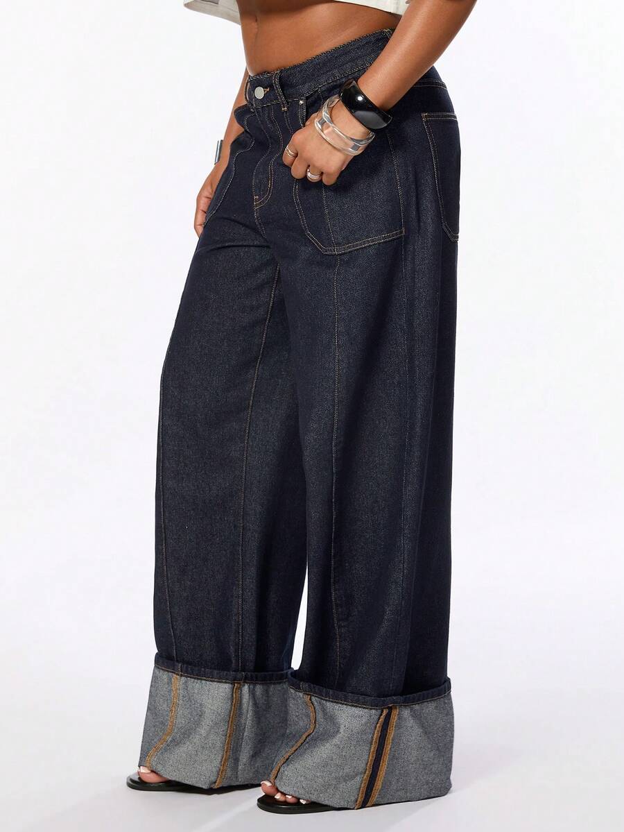 Front view of women's blue low waist flared denim jeans featuring a raw wash finish, loose straight leg fit, and zipper fly closure.