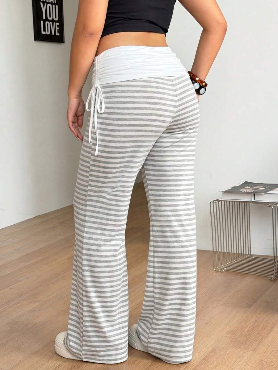 Women's striped flare leg pants featuring a mid-rise waist, slim fit thigh, and ruched side drawstring detail in stretch knit fabric.