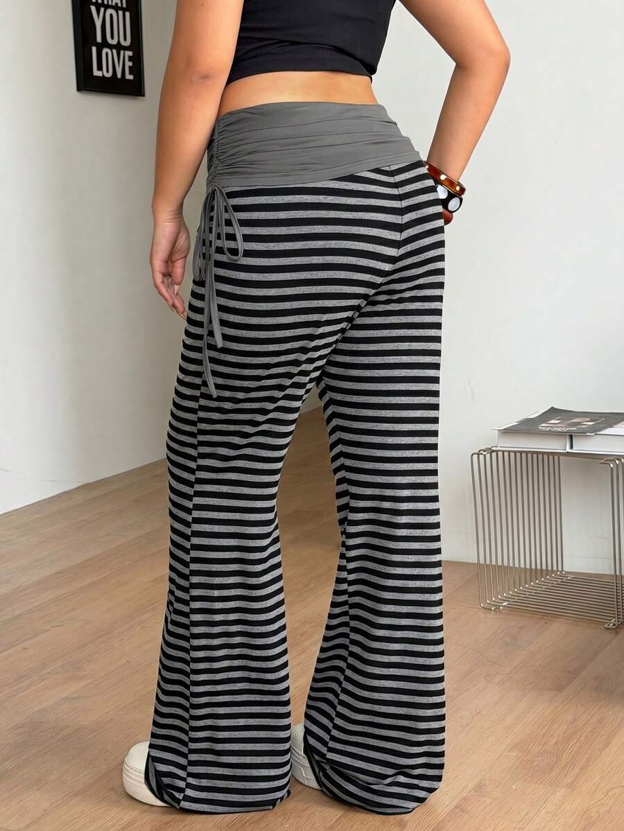 Women's striped flare leg pants featuring a mid-rise waist, slim fit thigh, and ruched side drawstring detail in stretch knit fabric.