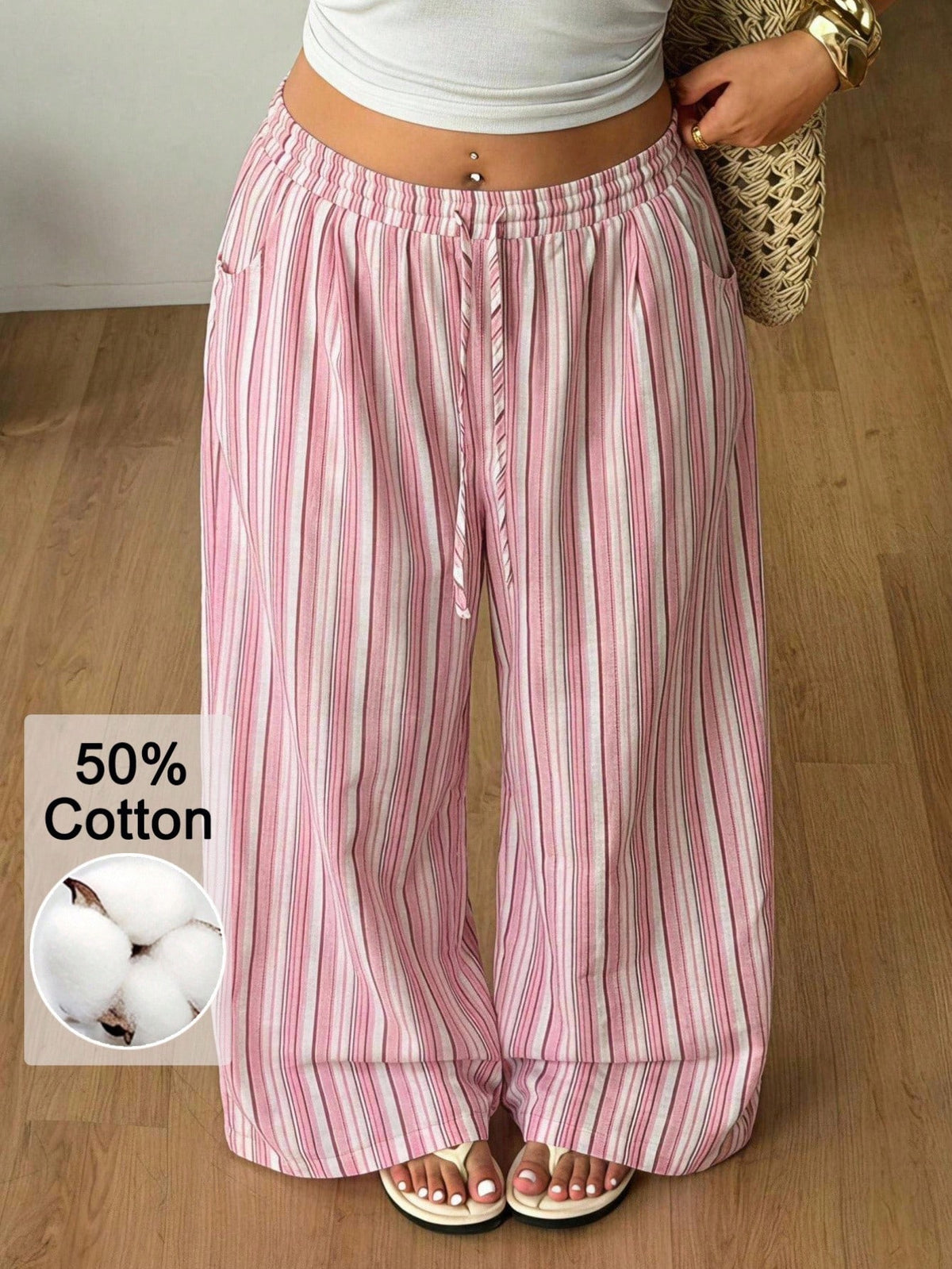 Women's loose straight leg cotton pants featuring a high waist with an adjustable drawstring knot and functional side pockets.