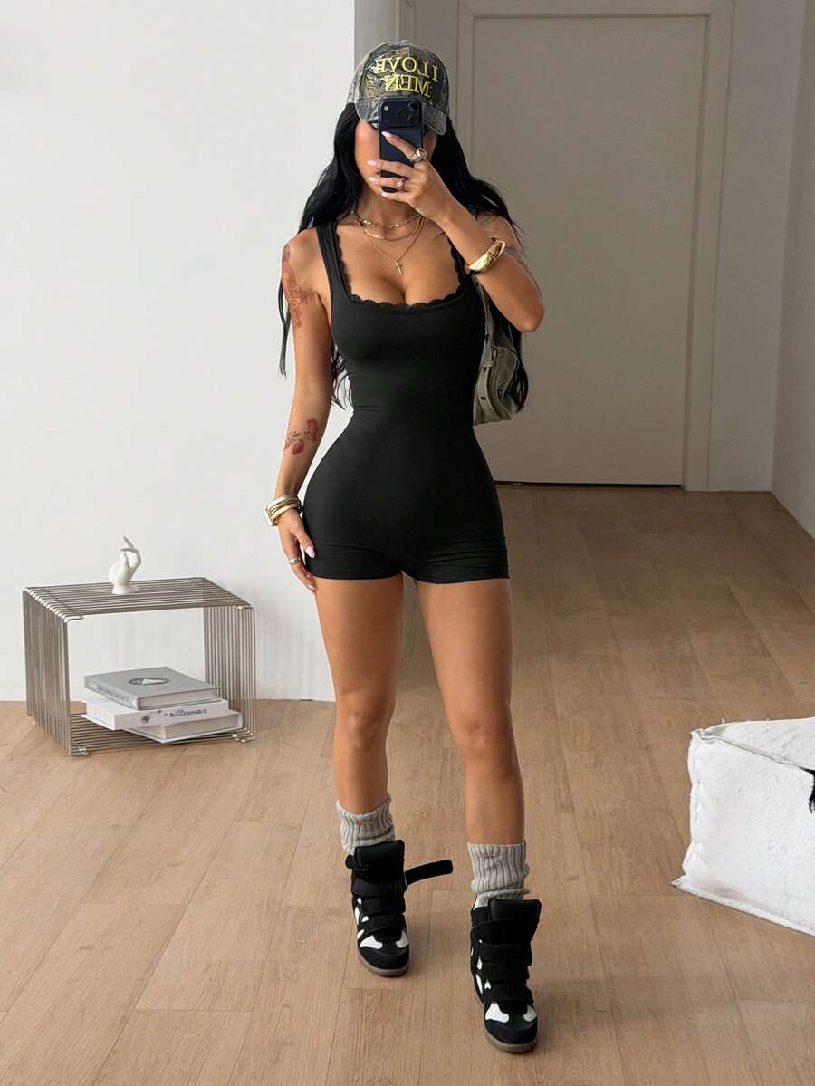 Women's black sleeveless unitard romper with a square neckline and backless design in stretchy knitted fabric.